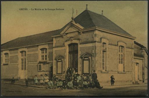 La mairie et le groupe scolaire, avec les élèves posant devant l'entrée du bâtiment.