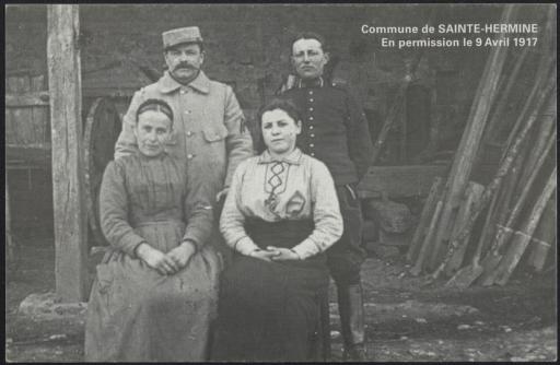 Deux soldats en permission posent avec leur femme dans une grange, à Sainte-Hermine.