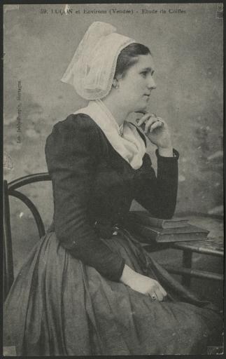 Luçon et environs. - Une jeune femme, en costume portant la coiffe, assise de profil, accoudée sur des livres posés sur une table.