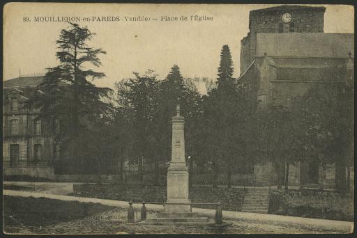 Le monument aux morts sur la place de l'Église, avec le presbytère et l'église en arrière-plan.