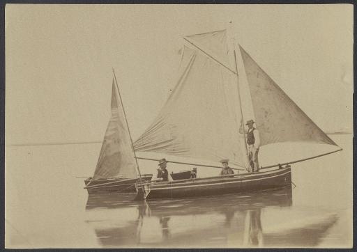 (213 J 95). Deux hommes et un enfant à bord d'un bateau à voile.